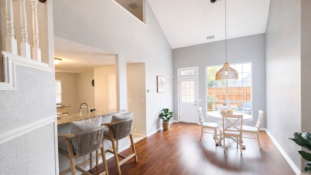 A spacious kitchen with a central island, wooden chairs, and a dining table. - Modern Texas Home. Prime Frisco Location (Frisco)