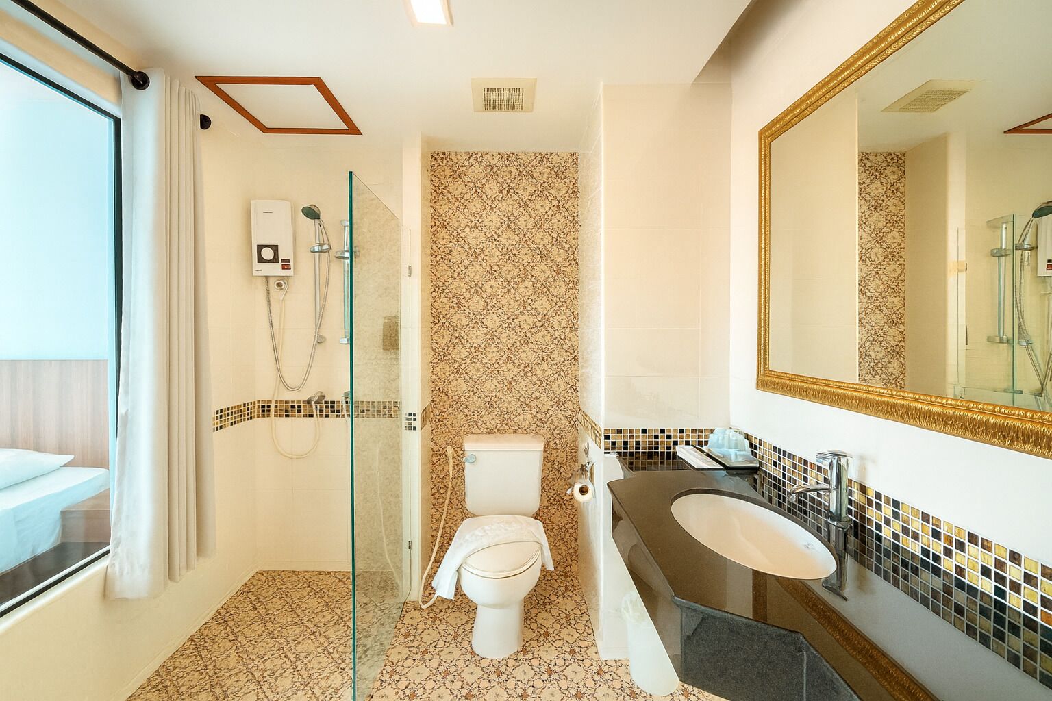 A modern bathroom with a glass shower enclosure, a toilet, a sink, and a large mirror.
