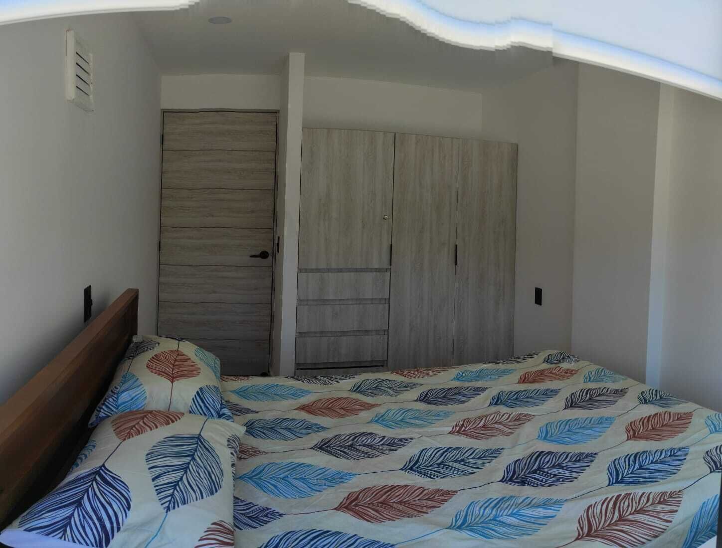 Ein Schlafzimmer mit Bett, Kleiderschrank und Tür.