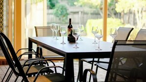 Een terras met een tafel voor twee, compleet met een fles en meerdere wijnglazen.