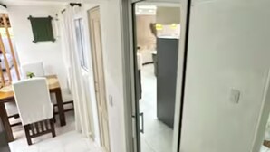 A modern interior with a dining area, a sliding glass door leading to a kitchen, and a tiled floor. - Enjoyable 1-bedroom apartment with AC in vibrant Sosúa (Sosúa)