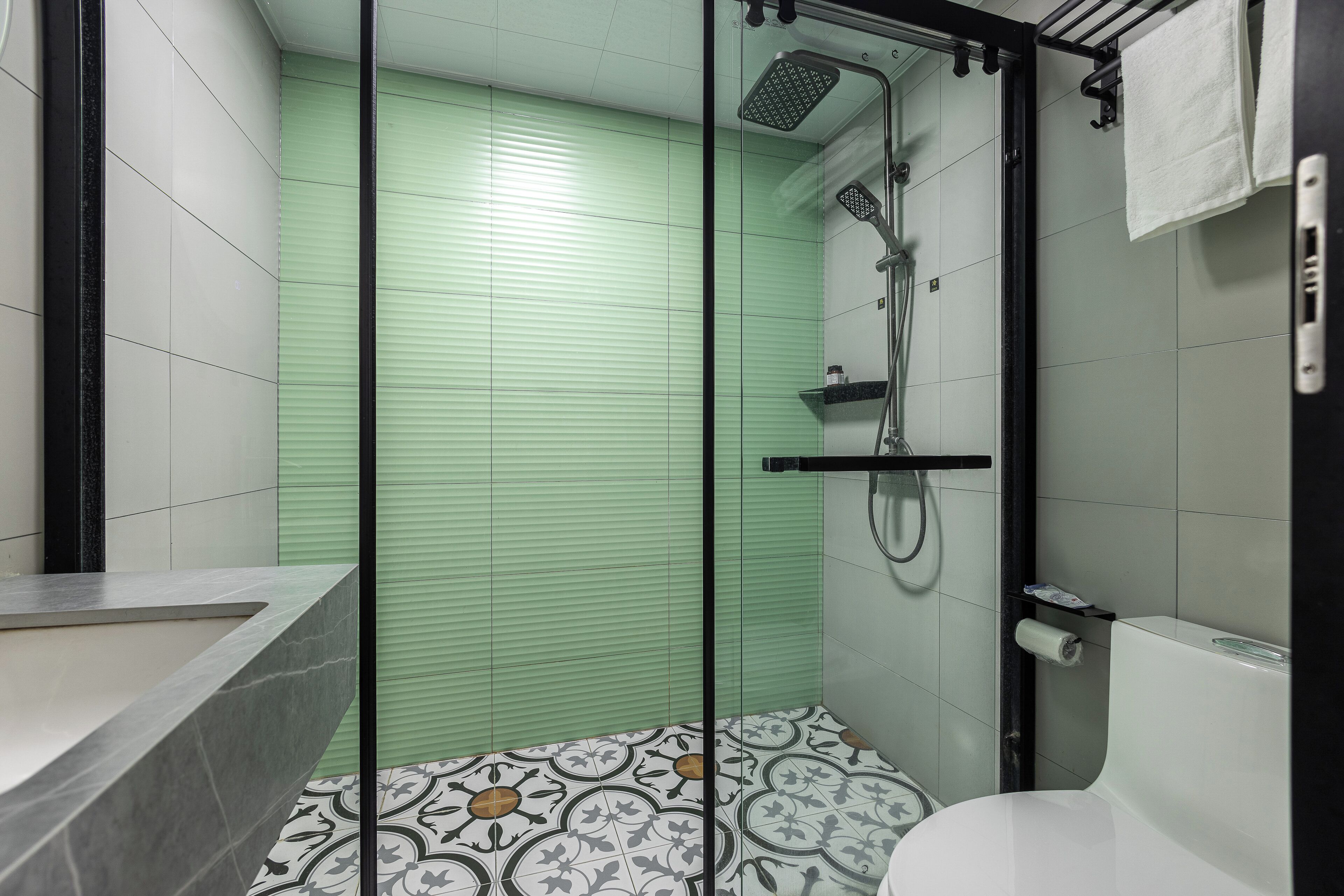 A bathroom with a shower, toilet, and sink.