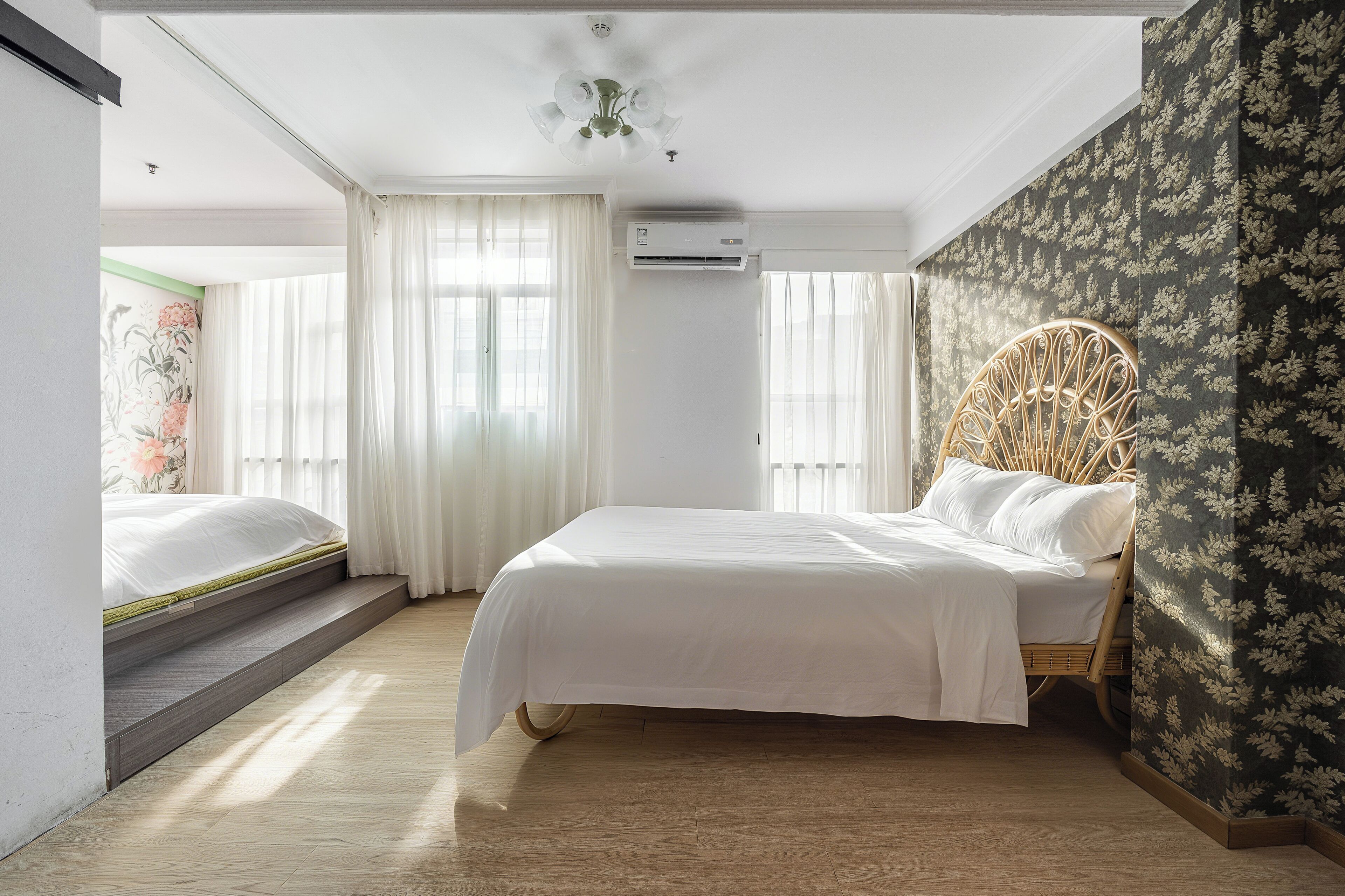 Un dormitorio con cama, un banco empotrado, ventilador de techo y aire acondicionado.