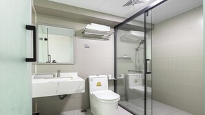 Un baño moderno con inodoro, lavabo y cabina de ducha de vidrio.