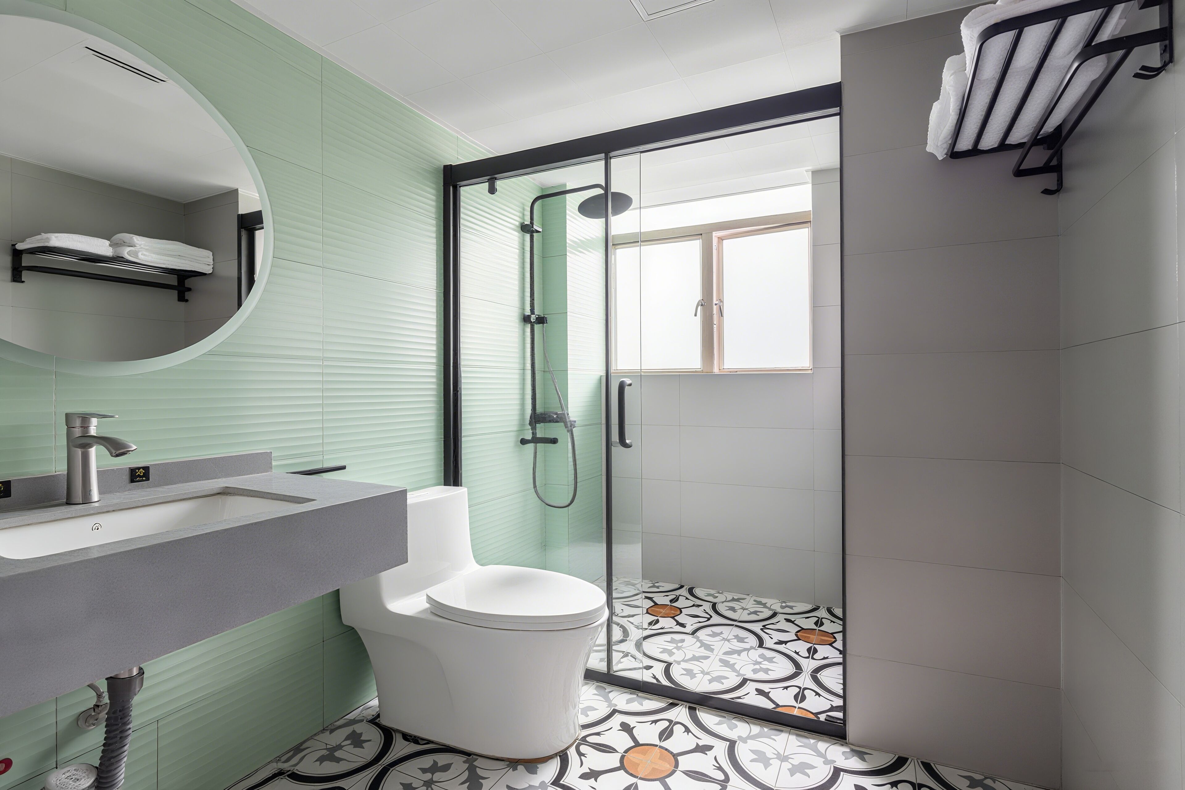 Un baño moderno con inodoro, lavamanos y ducha.