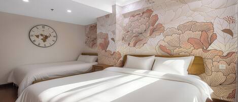 Habitación de hotel con dos camas, un reloj de pared grande y un diseño de papel tapiz floral.