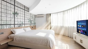 A modern bedroom with a large bed, a TV on a white cabinet, and a wall with a grid pattern. - VanInn Guangzhou , Step Out to Beijing Road Pedestrian Street , Gongyuanqian & Beijing Road Metro - Canton Fair (Guangzhou)