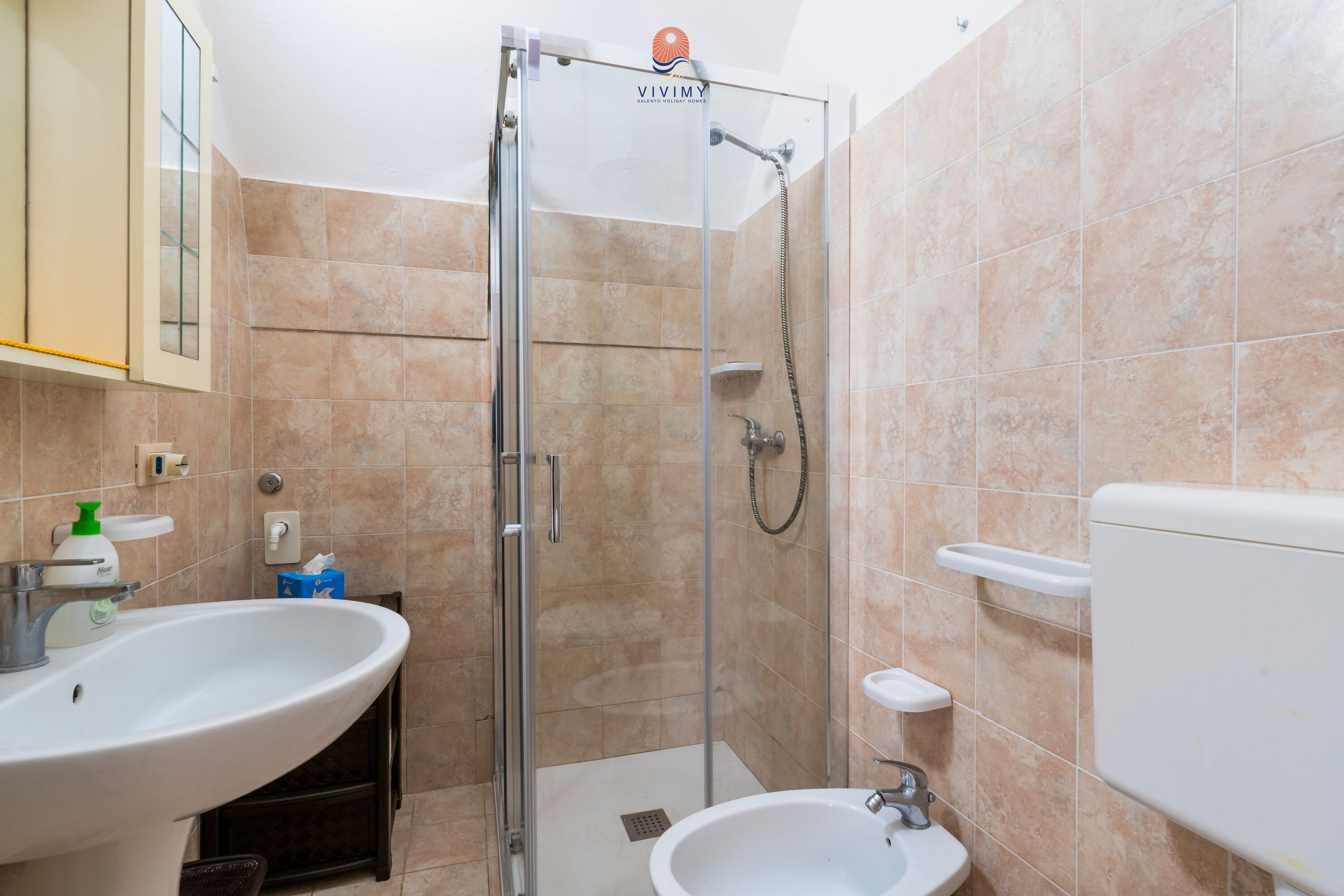 A bathroom with a shower, sink, and toilet.