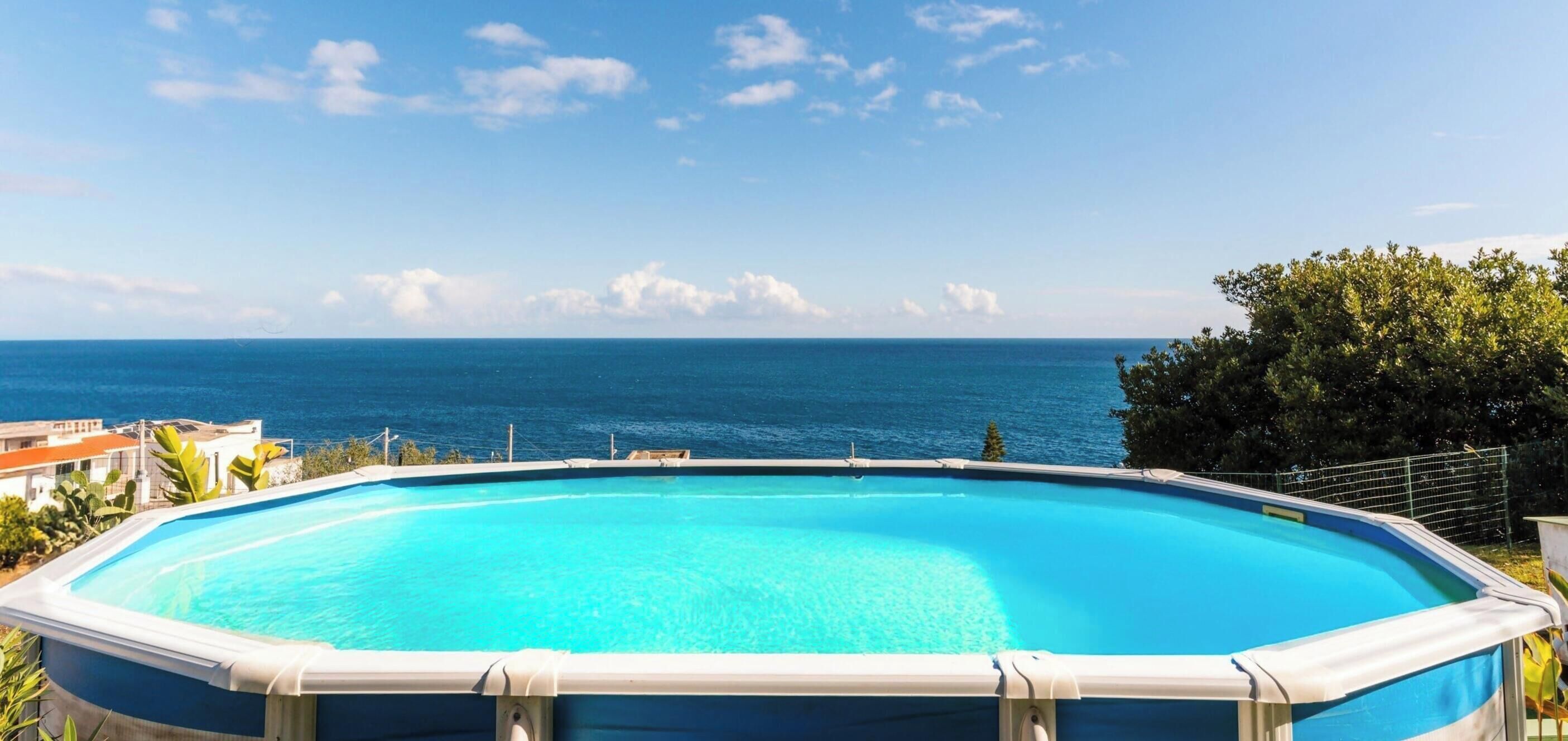 An outdoor swimming pool with a view of the ocean.