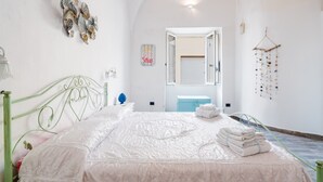 A bedroom with a bed, a dresser, a mirror, and a wall decoration. - Nita House by Vivimy (Racale)