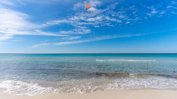 A beach with clear water, a sandy shore, and a clear sky. - Nita House by Vivimy (Racale)
