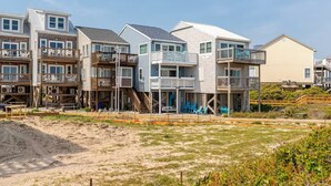 Eine Wohngegend direkt am Strand mit mehrstöckigen Häusern, die Balkone und Außenbereiche zum Sitzen haben.