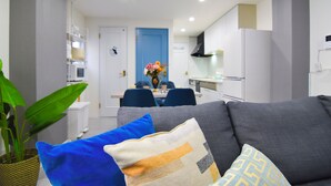 A modern living room with a grey sofa, blue and patterned cushions, and a dining area in the background. - 1 minute to Universal Studios Japan! Spend a relaxing time in a stylish house with free parking! (Osaka city Konohana-ku Shimaya)