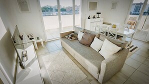 A modern living room with a sofa, a small table, and a cabinet. - Rental of a T3 for 6 in a residence with swimming pool, 900m from the beach. (LE LAVANDOU)