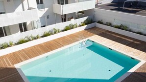 A rooftop swimming pool with a wooden deck and a glass barrier. - Rental of a T3 for 6 in a residence with swimming pool, 900m from the beach. (LE LAVANDOU)