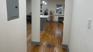 A modern kitchen with wooden flooring, a built-in island, pendant lighting, and a window with a view. - 2-bedroom apartment in cool Bronx with refreshing AC (Bronx)