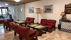 Ein gemütlicher Aufenthaltsbereich mit Holzmöbeln, einem Kamin und Kunstwerken an den Wänden.