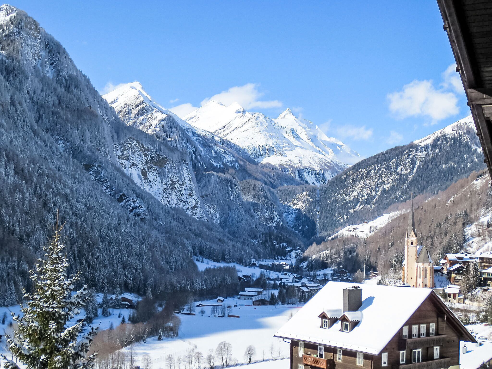 A mountain village with snow-covered buildings and a church.