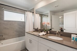 A modern bathroom with a bathtub, two sinks, a large mirror, and a potted orchid. - Family Private Pool Villa Near Disney & Universal
BBQ+Resort+LazyRiver+Waterpark (Kissimmee)