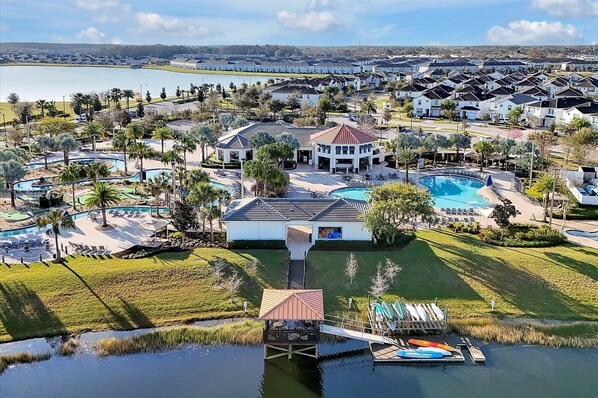 A resort with multiple swimming pools, a dock with kayaks, and a large building with a distinctive roof. - Family Private Pool Villa Near Disney & Universal
BBQ+Resort+LazyRiver+Waterpark (Kissimmee)