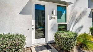 Un edificio moderno con facciata bianca, una porta in vetro e il numero 308.