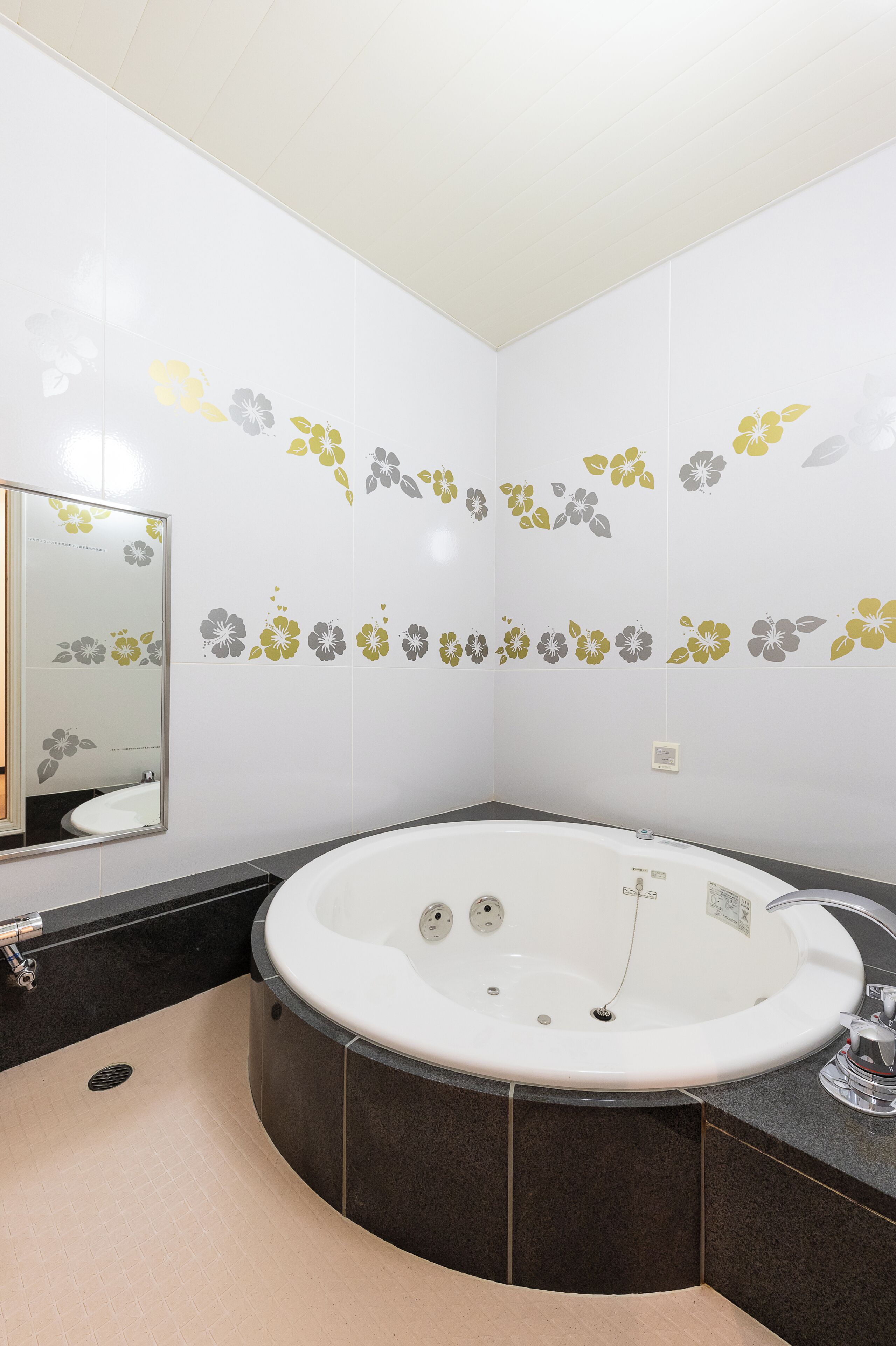A bathroom with a large bathtub, a sink, and a mirror.