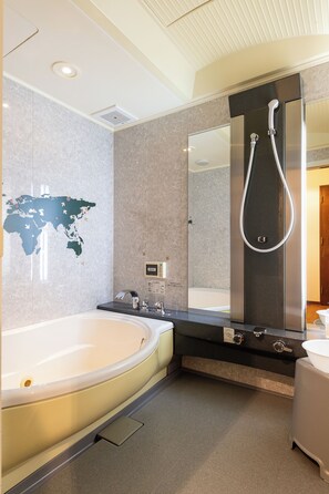 Ein modernes Badezimmer mit einer großen Badewanne, einer Dusche, einem Waschtisch mit Spiegel und einer Weltkarte an der Wand.
