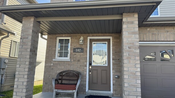 A house with a porch, a door with a number plate, and a chair. - Cozy Queen Room Near Hospital | Quiet & Clean Home (Napanee)