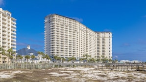 A beachfront hotel with multiple floors, a beach view, and a wooden boardwalk. - Beach Club Condos  (Gulf Shores)