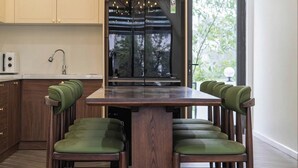 Une cuisine moderne avec des meubles en bois, un îlot central doté de chaises et une grande fenêtre.