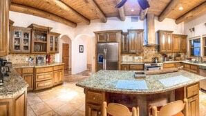 Una cocina amplia con encimeras de granito, armarios de madera y una isla grande.