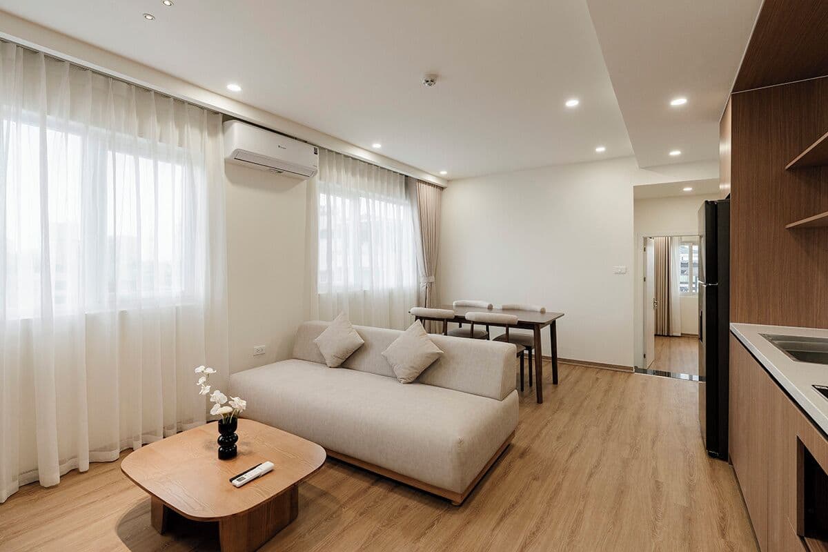 A modern living room with a sofa, a coffee table, and a dining area.