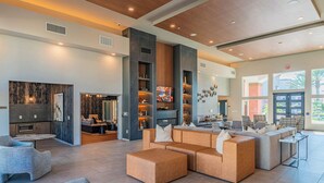 A spacious living area with a large sectional sofa, a fireplace, and a modern entertainment unit. - Westgate Area Balcony, Pool, Gym Parking WD (Glendale)