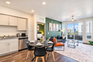 A modern apartment with a kitchen, dining area, and living space. - City Retreat | Balcony | Pool | Gym | Free Parking (Glendale)