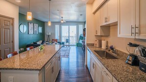 A modern kitchen with granite countertops, white cabinets, and a central island.