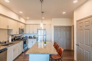 A modern kitchen with granite countertops, stainless steel appliances, and a central island with seating. - Westgate Near Stadium Balcony Pool Parking Gym WD (Glendale)