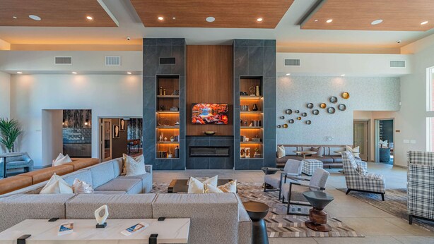 A modern living room with a fireplace, comfortable seating, and a television. - Near Stadium | Pool Gym Balcony Parking WD (Glendale)