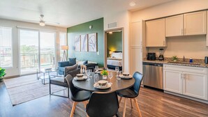 A modern kitchen with white cabinets, a dishwasher, and a coffee maker. - Near Stadium | Pool Gym Balcony Parking WD (Glendale)