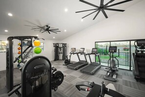 A gym with treadmills, weight machines, and a ceiling fan. - Near Old Town | Pool+Gym+Balcony+Parking+WiFi+WD (Scottsdale)