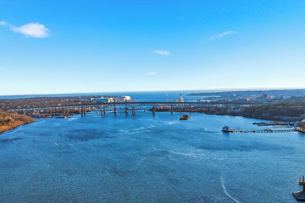 A river with a bridge, boats, and docks. - Riverview Retreat: Guest Suite (Groton)