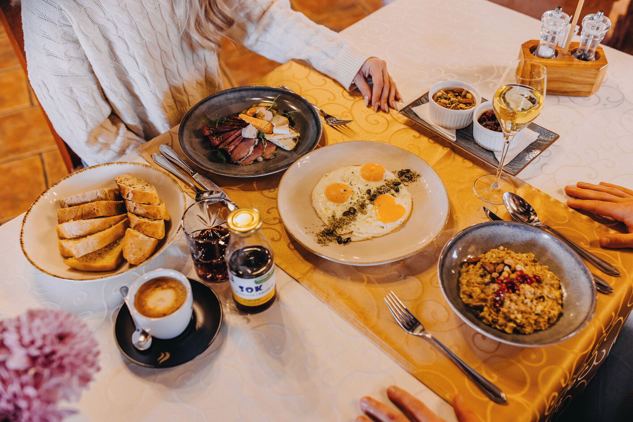 Un desayuno con diferentes platos, una botella de licor y una taza de café.