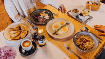 Un desayuno con diferentes platos, una botella de licor y una taza de café.
