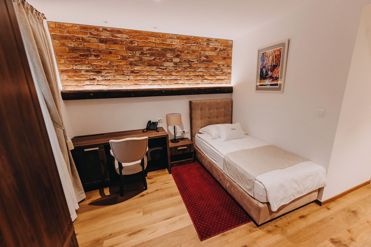 Quarto solteiro conforto | Roupas de cama premium, frigobar, cofres nos quartos, escrivaninha