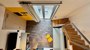 A modern interior with a staircase, a skylight, and a kitchen area. - HC Hotel Manerbio Loft (Manerbio)