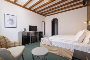 A bedroom with a bed, a desk with a computer, a chair, and a small table. - Hotel Razlog (Razlog)