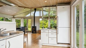 A modern kitchen with a built-in stove, white cabinets, and a large window overlooking a garden. - "Ilwith" - 400m from the sea by Interhome (Børkop)