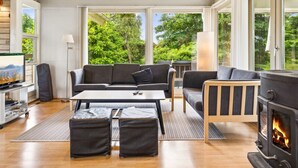 A modern living room with a sofa, coffee table, ottomans, a fireplace, and a television. - "Ilwith" - 400m from the sea by Interhome (Børkop)