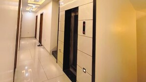 A modern hallway with a sleek elevator and a staircase. - Hotel Vistara (Ujjain)
