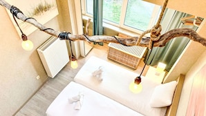 A modern bedroom with a large bed, two bedside tables, and a unique branch light fixture. - Beautiful private villa for 4 people with WIFI, TV and terrace (Bruges)