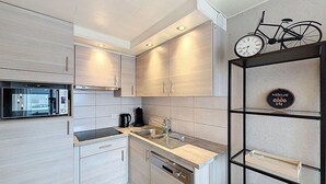 A modern kitchen with built-in appliances, a bicycle decoration, and a welcome sign. - Beautiful private villa for 4 people with WIFI, TV and terrace (Bruges)